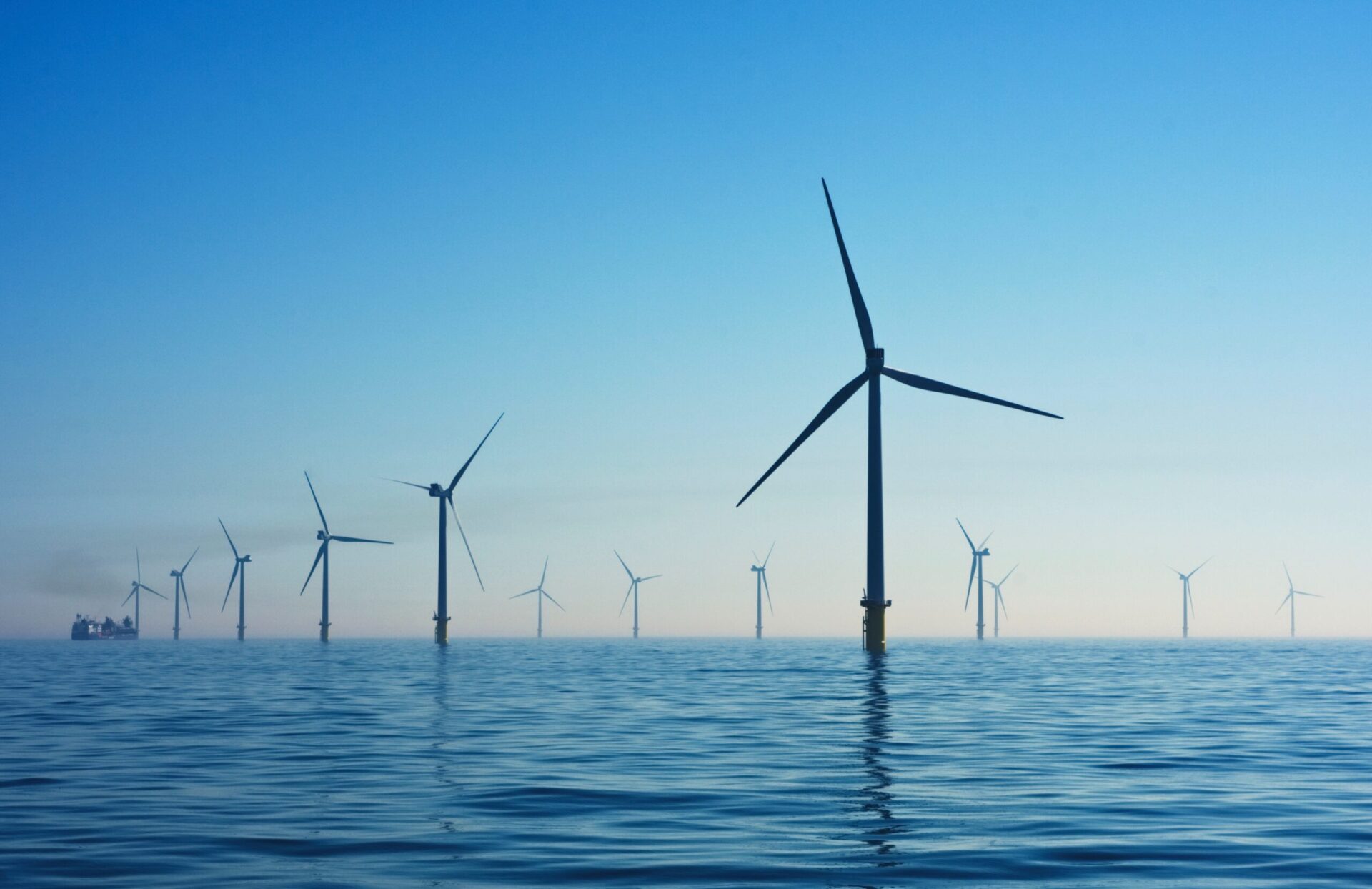 wind turbines in the ocean at sunset