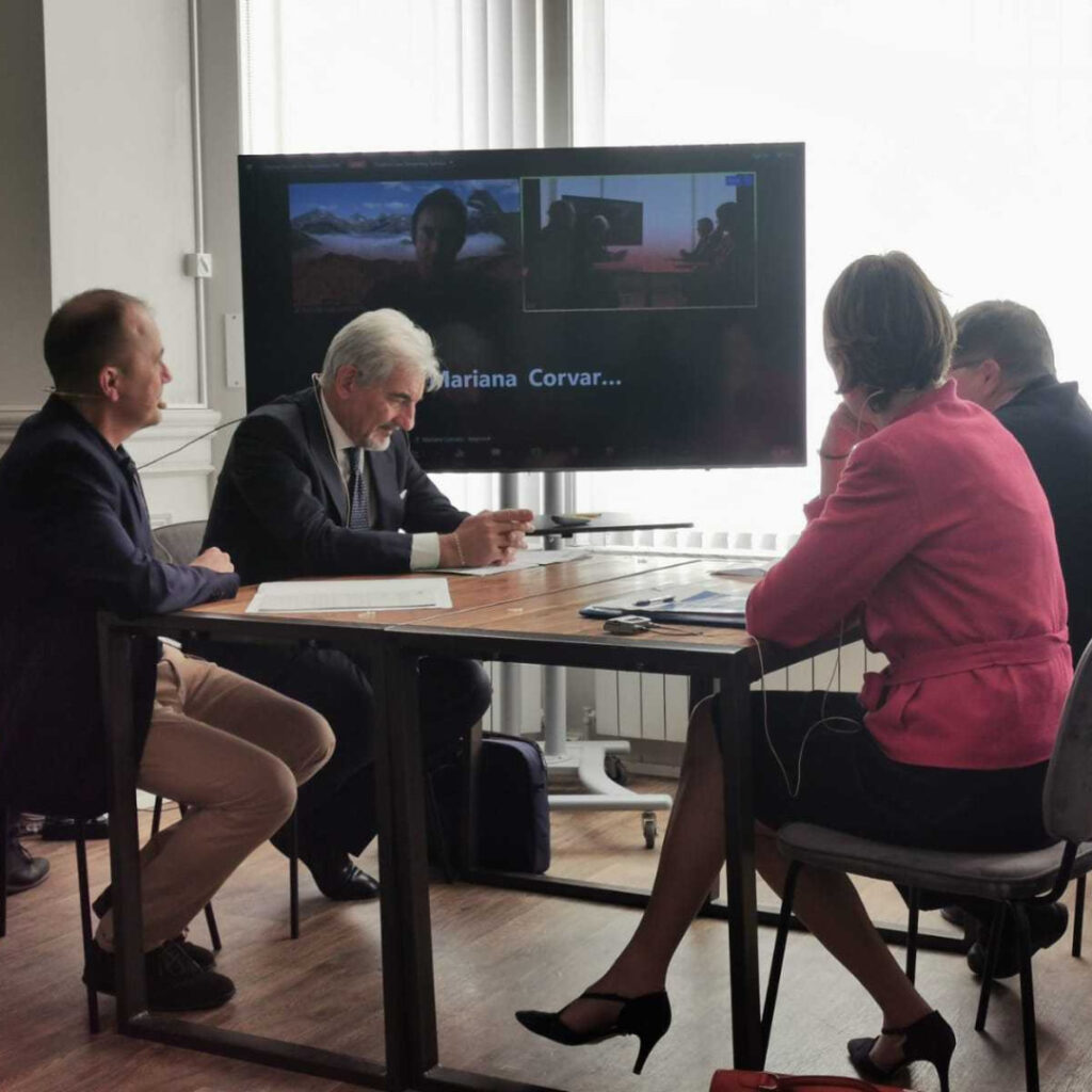 People sitting around a table with screen in background